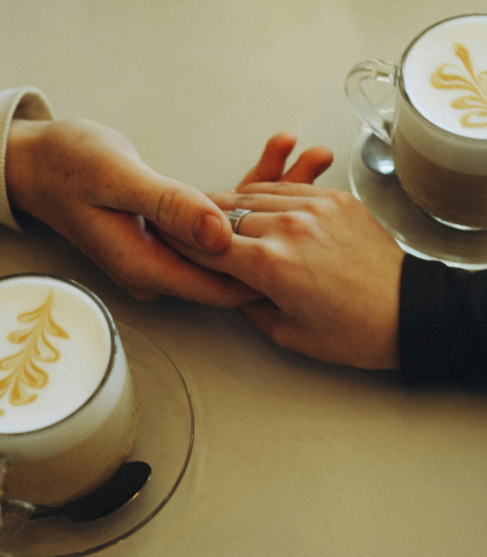 holding hands over coffee