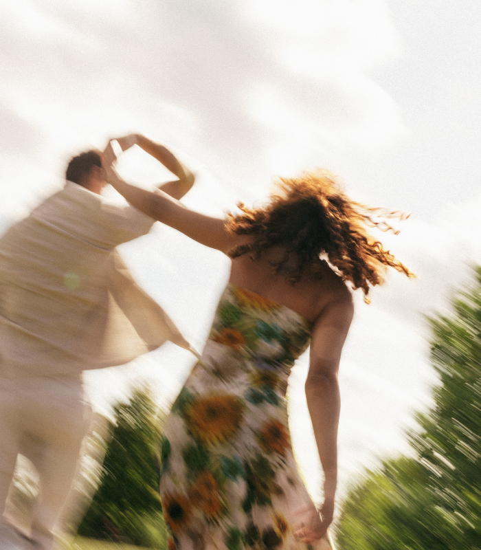 couple twirling in field 