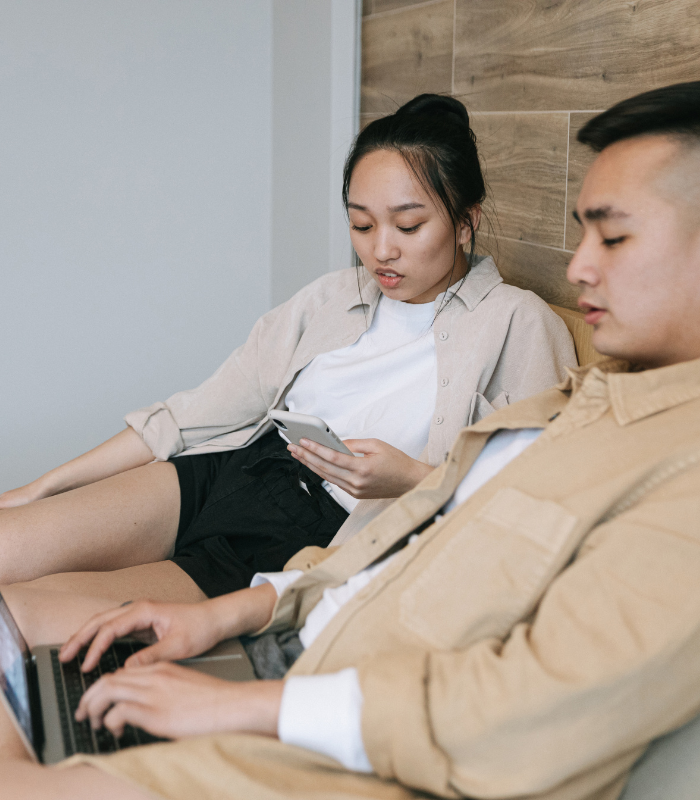 couple looking at laptop together in bed 
